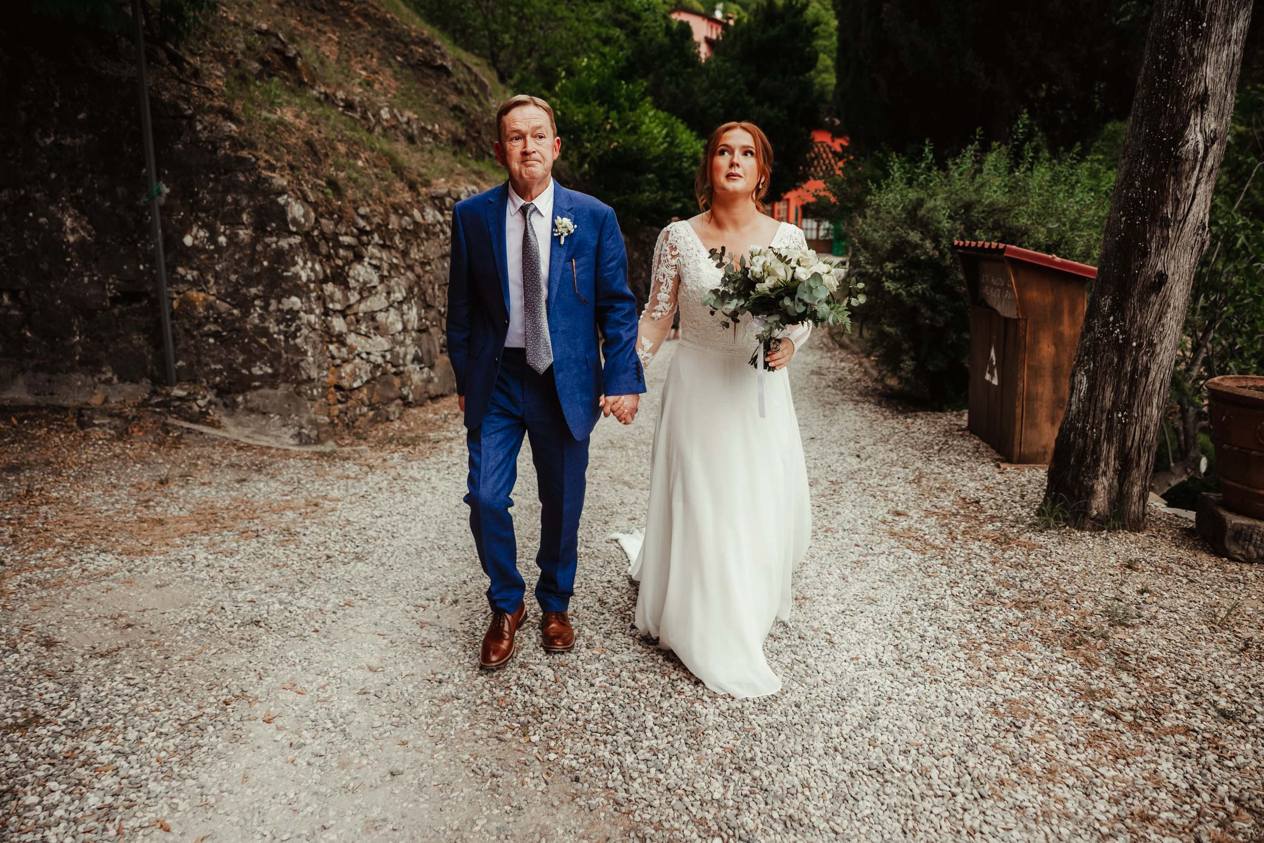 bride and dad look nervous as the walk to hilltop ceremony in Tuscany Italy
