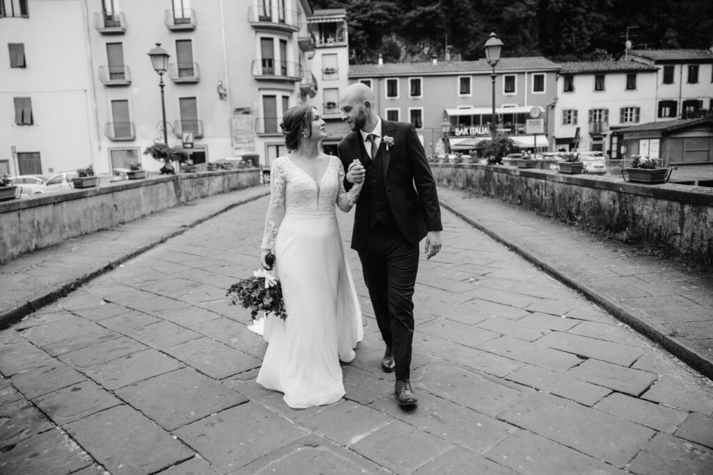 bride and groom walk across bride in the town of Bagni di Lucia