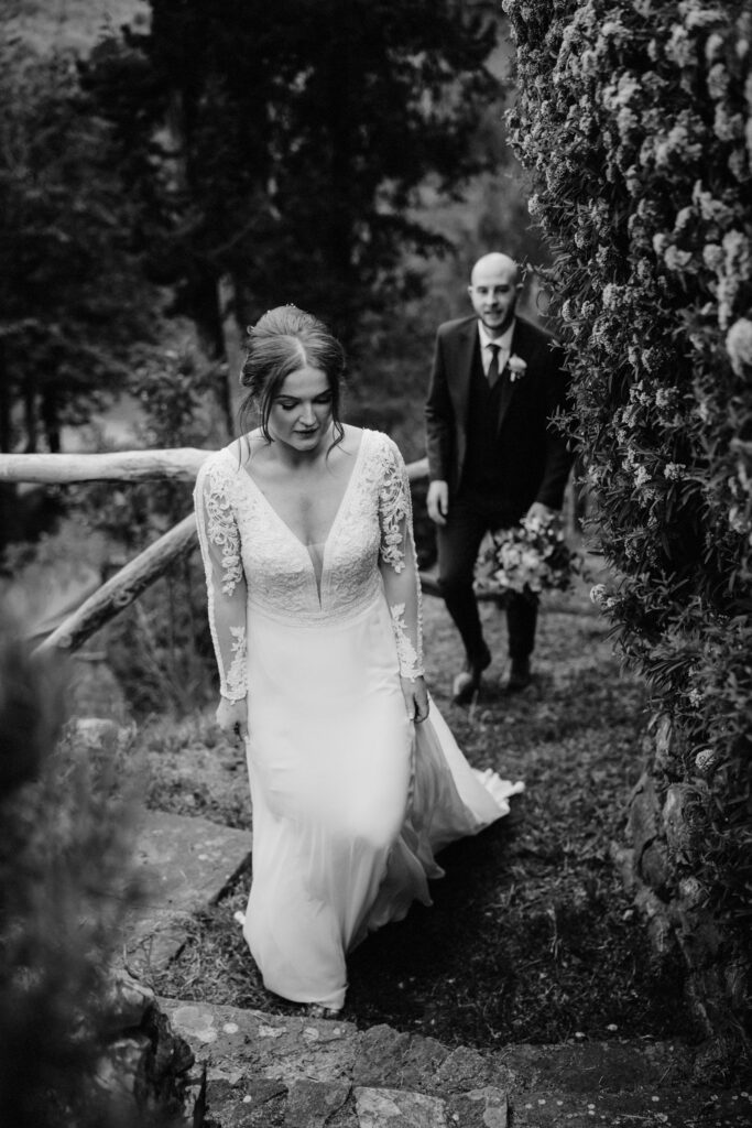 pride and groom walk through hillside vineyard in Tuscany Italy