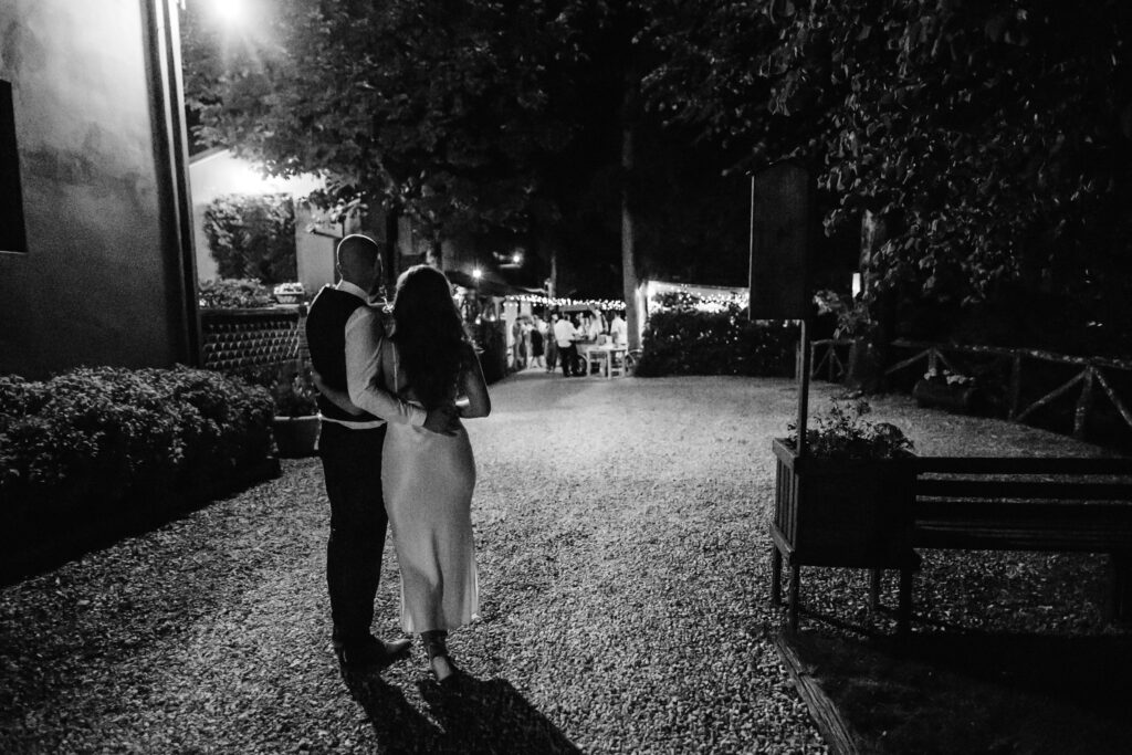 bride and groom in the dark looking at their outdoor dance area in Tuscany
